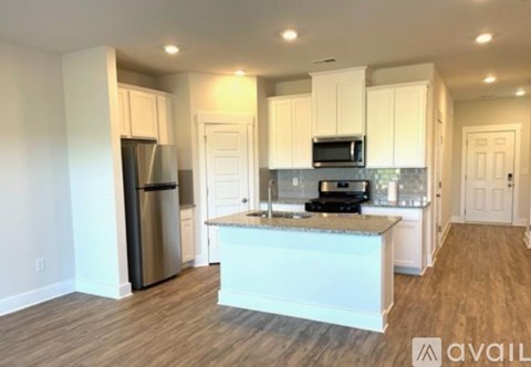 A kitchen with white cabinets and a marble countertop.