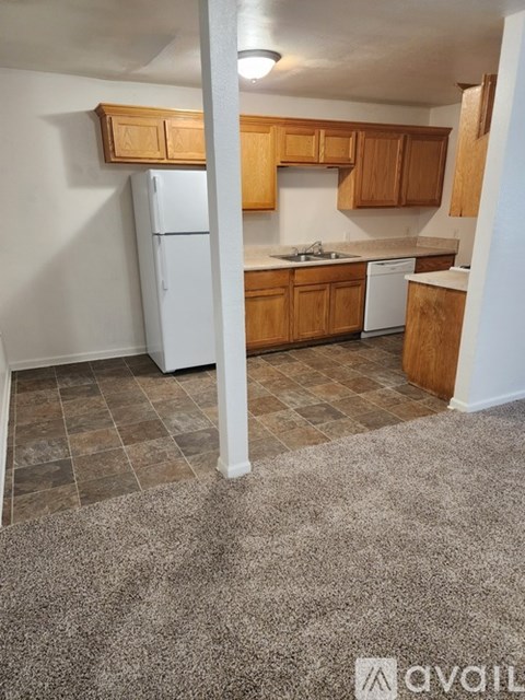 A kitchen with wooden cabinets and a white refrigerator.