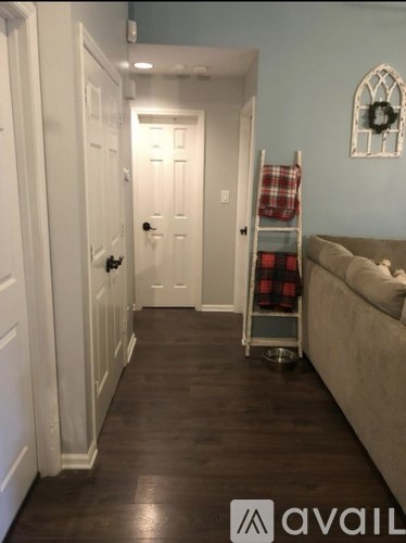 A hallway with a couch and a ladder.