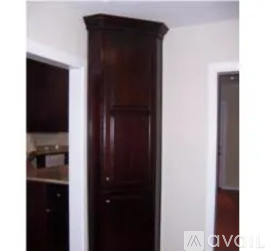 A tall wooden cabinet stands in a room.