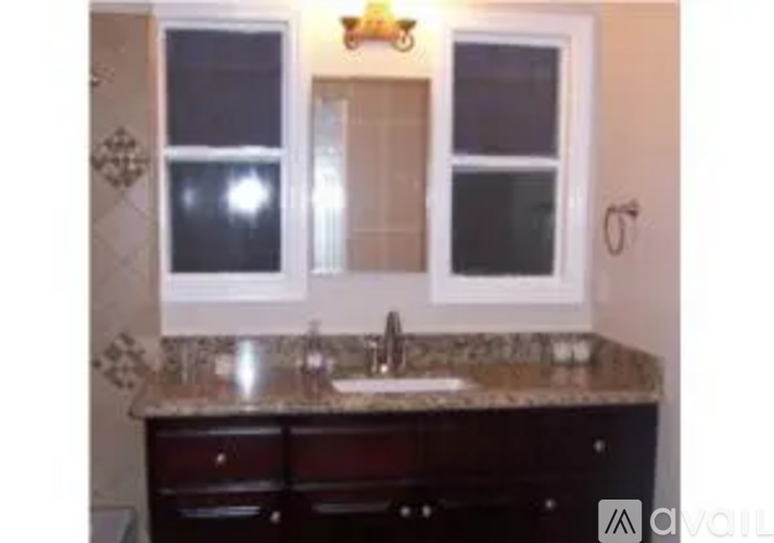 A bathroom with a sink and a window.