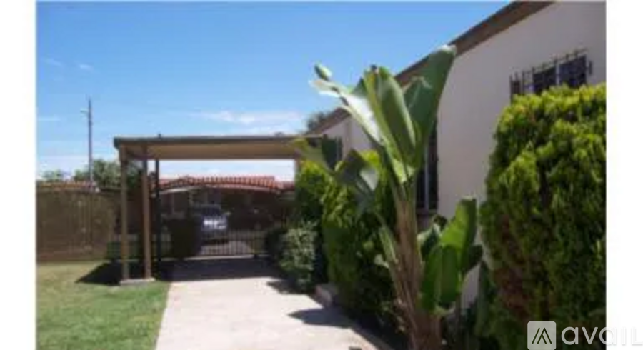 A house with a red gate and a green plant in front.
