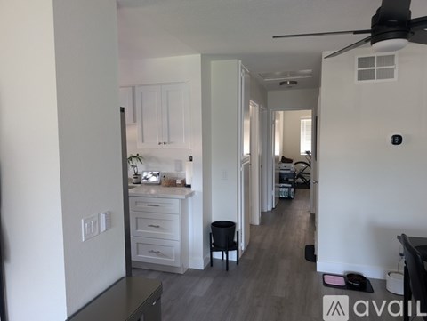 A living room with a black chair and a fan.