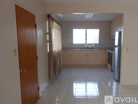A kitchen with a refrigerator, sink, and cabinets.