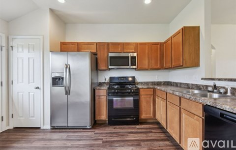 A kitchen with wooden cabinets and a stainless steel refrigerator.