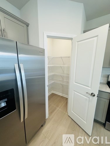 A kitchen with a stainless steel refrigerator and white door.
