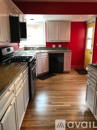 A kitchen with wooden floors and a granite countertop.