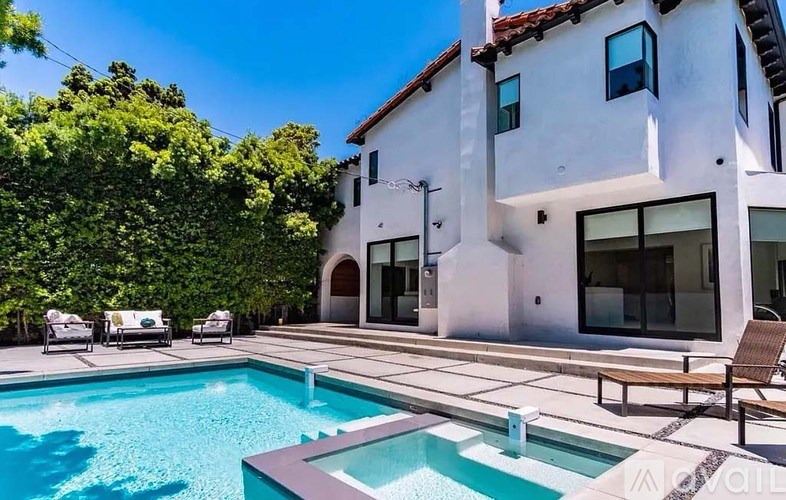 A white house with a pool in front.