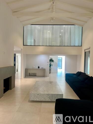 A living room with a black couch and a fireplace.