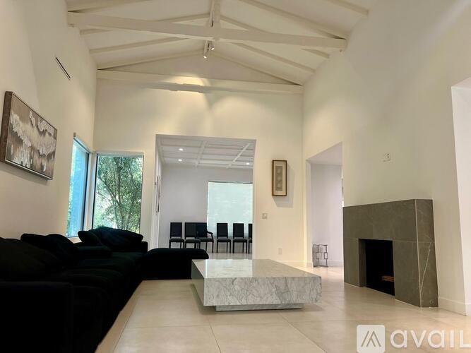 A living room with a black couch and a fireplace.