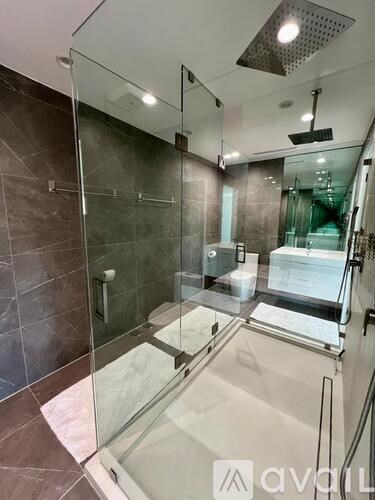 A modern bathroom with a glass shower stall and a walk-in shower.