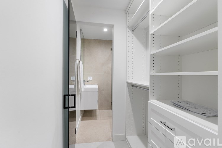 A white bathroom with a walk-in shower and a vanity with a sink.