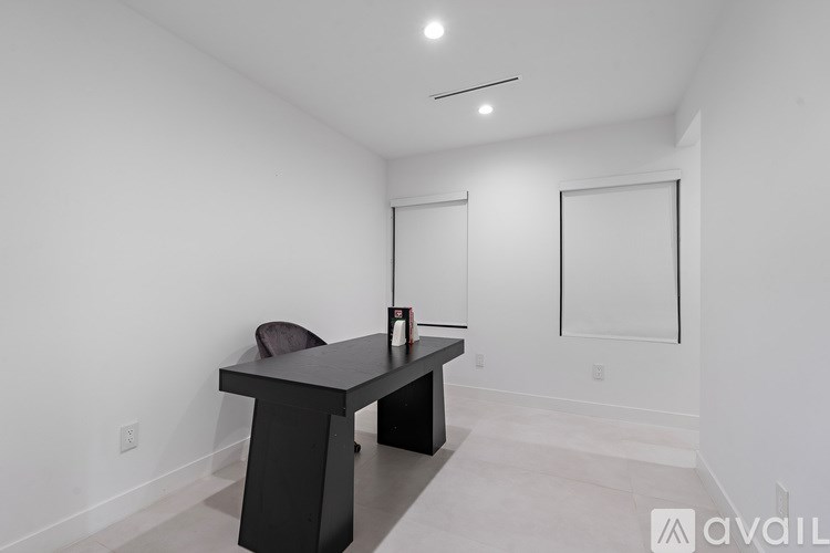 A black table with a purple chair in a white room.