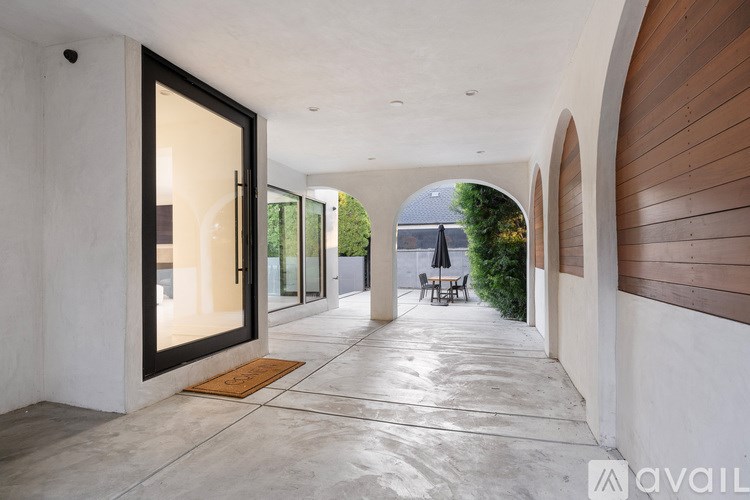 A modern house with a long hallway and a door on the left.