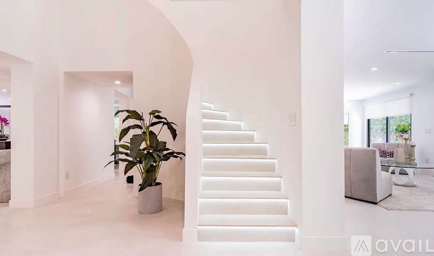 A white staircase with a plant on the landing.