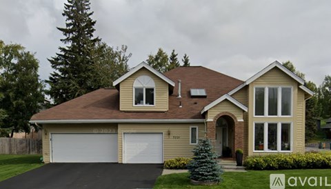 A house with a brown roof and a garage door is for sale.