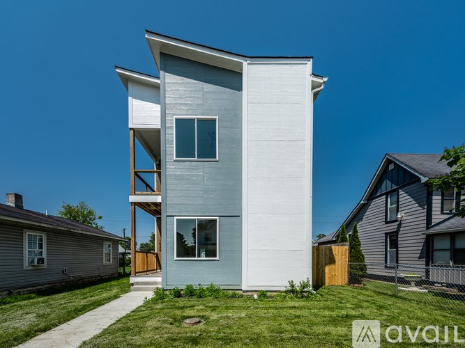 A modern two-story house with a balcony on the second floor.