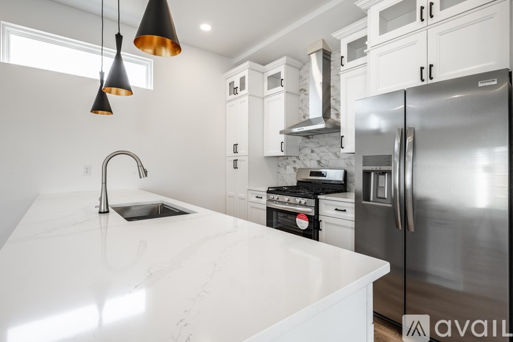 A kitchen with a white countertop and stainless steel appliances.