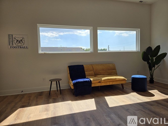 A room with a ceiling fan and a window with a view of a building outside.