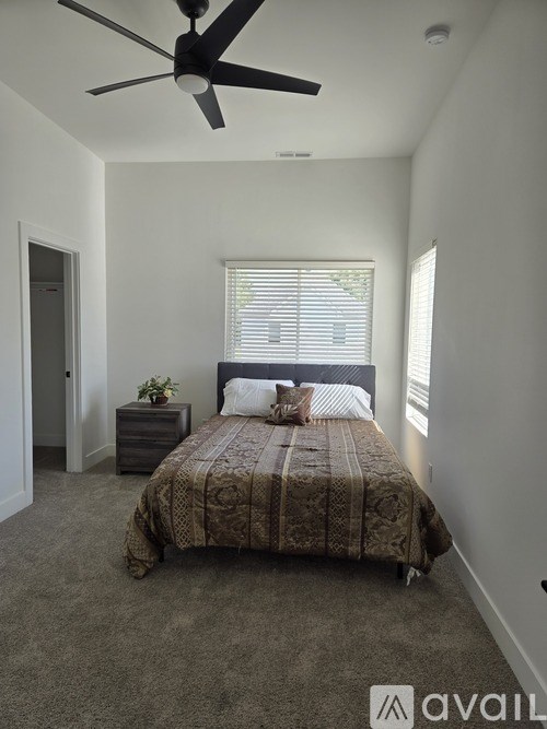 A spacious room with a ceiling fan and carpeted floor.