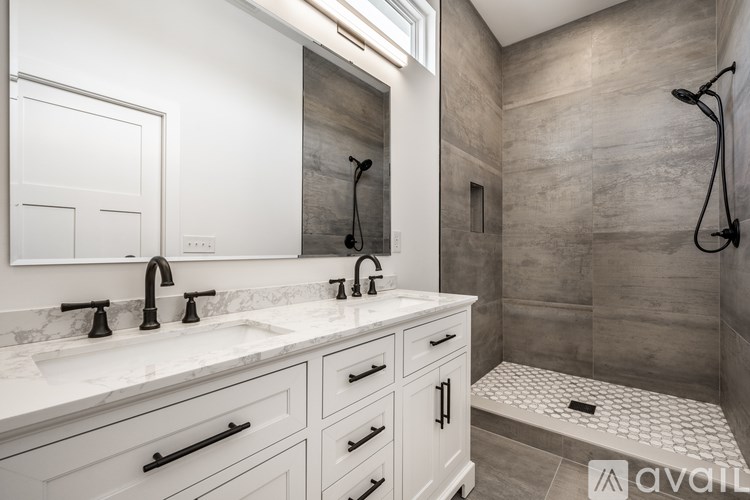 A bathroom with a marble countertop and a walk-in shower.
