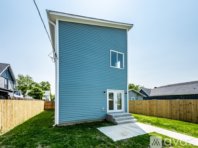 A blue house with a white door and a small window.