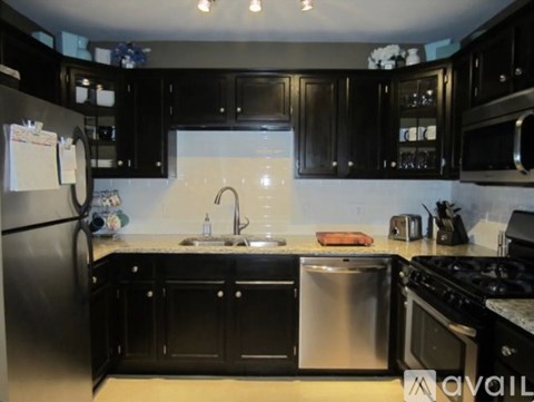 A kitchen with black cabinets and stainless steel appliances.