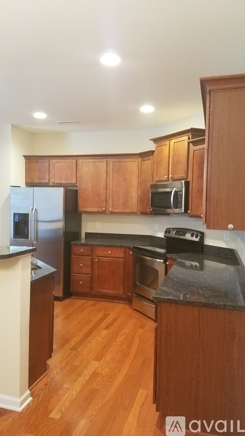 A kitchen with wooden cabinets and a black countertop.