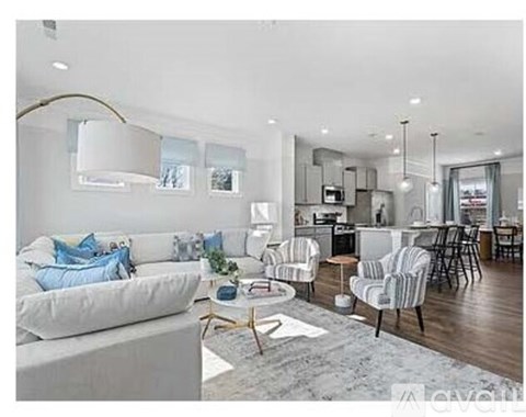 A modern living room with a white sofa and striped chairs.