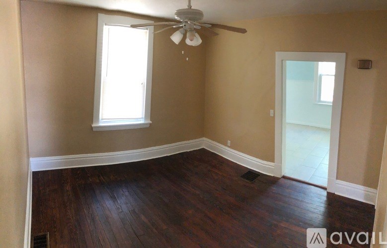A room with a ceiling fan and a window.
