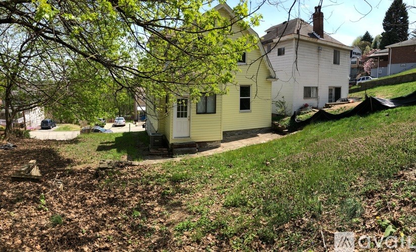 A yellow house with a white one behind it.