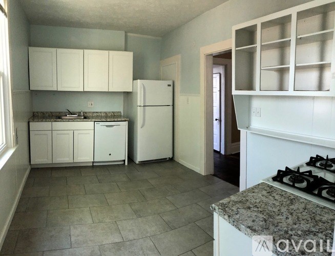 A kitchen with white appliances and cabinets.