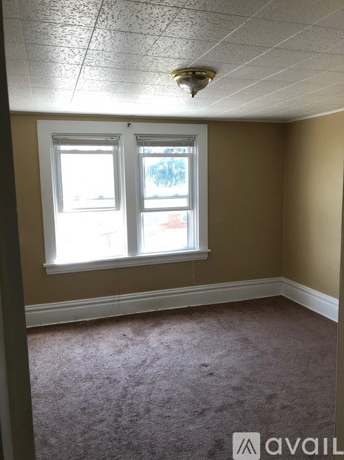 A room with a carpeted floor and a window.