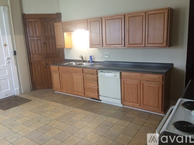 A kitchen with wooden cabinets and a tiled floor.