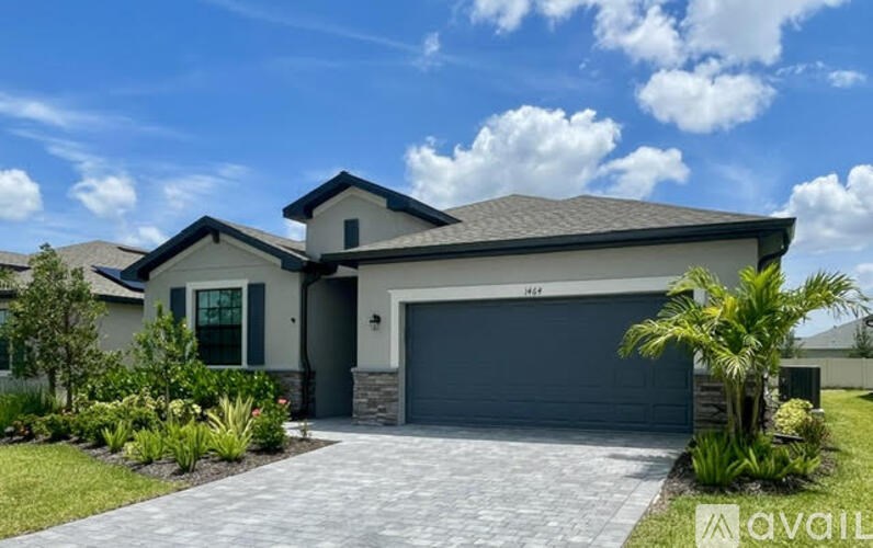 A house with a grey garage door and a driveway.