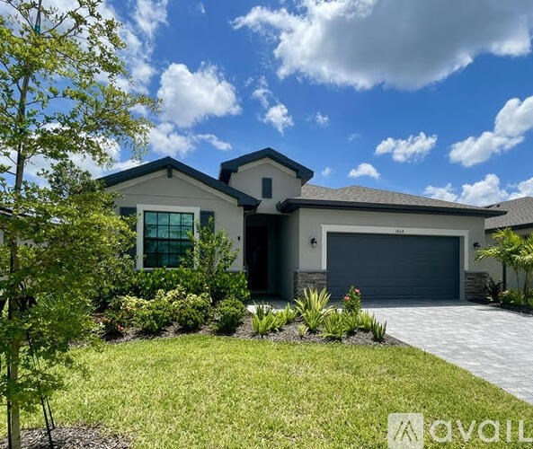 A modern house with a large front yard and a driveway.