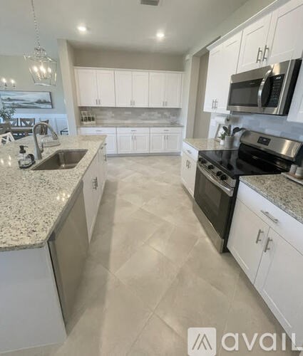 A kitchen with white cabinets and granite countertops.