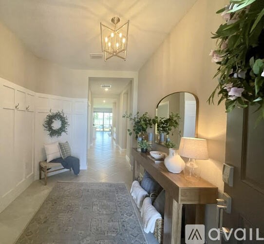 A hallway with a bench, a mirror, and a lamp.