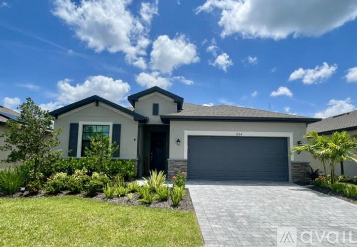 A modern house with a garage door and a driveway.