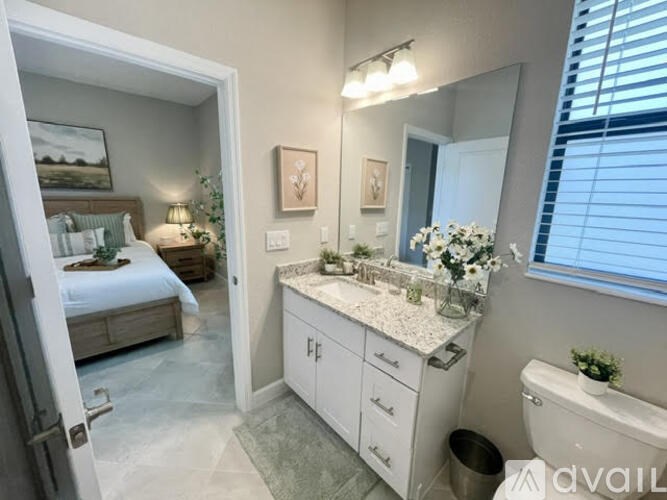 A bathroom with a bedroom door open to the bathroom.