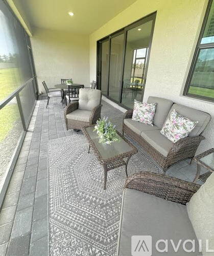A patio with a grey sofa, a coffee table, and a dining table.