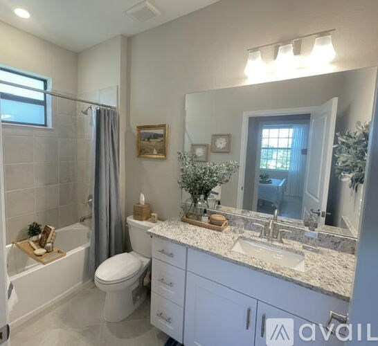A bathroom with a toilet, sink, and mirror.