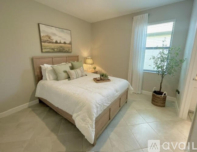 A bedroom with a large bed and a painting on the wall.