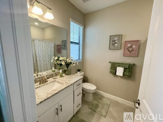 A bathroom with a toilet, sink, and mirror.