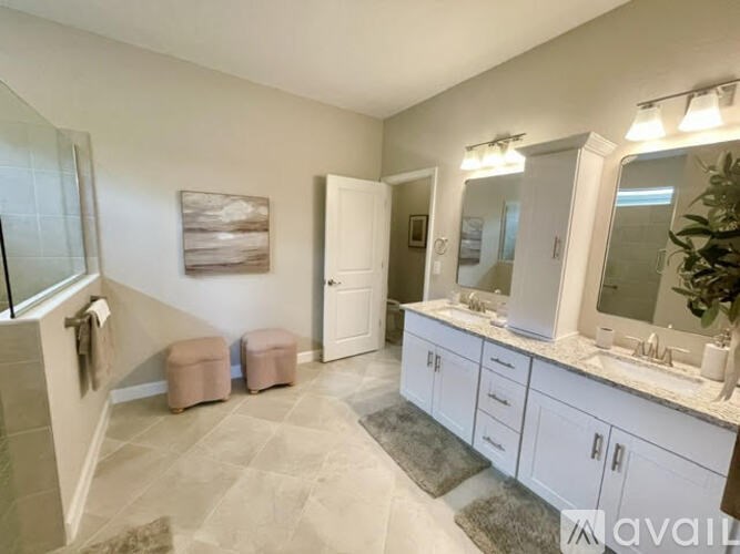 A bathroom with a white vanity and a large mirror.