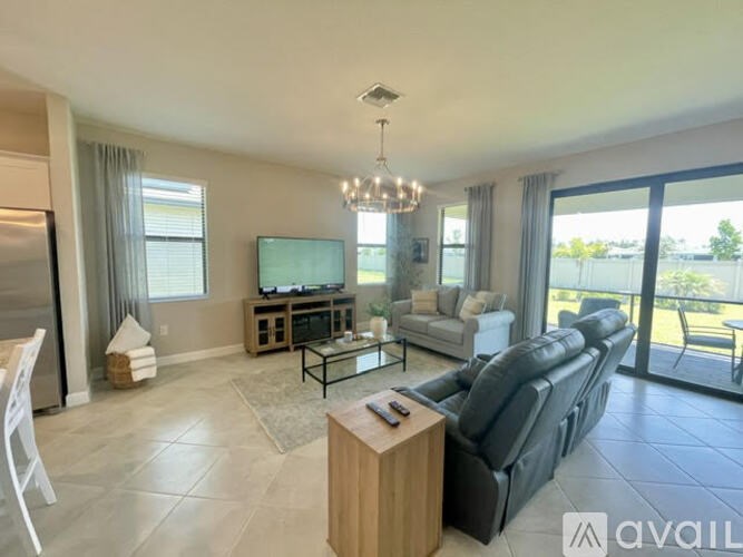 A living room with a black leather couch and a wooden coffee table.