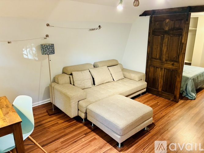 A living room with a white couch and a wooden floor.