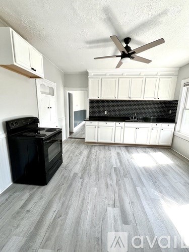 A kitchen with a black oven and wooden floors.