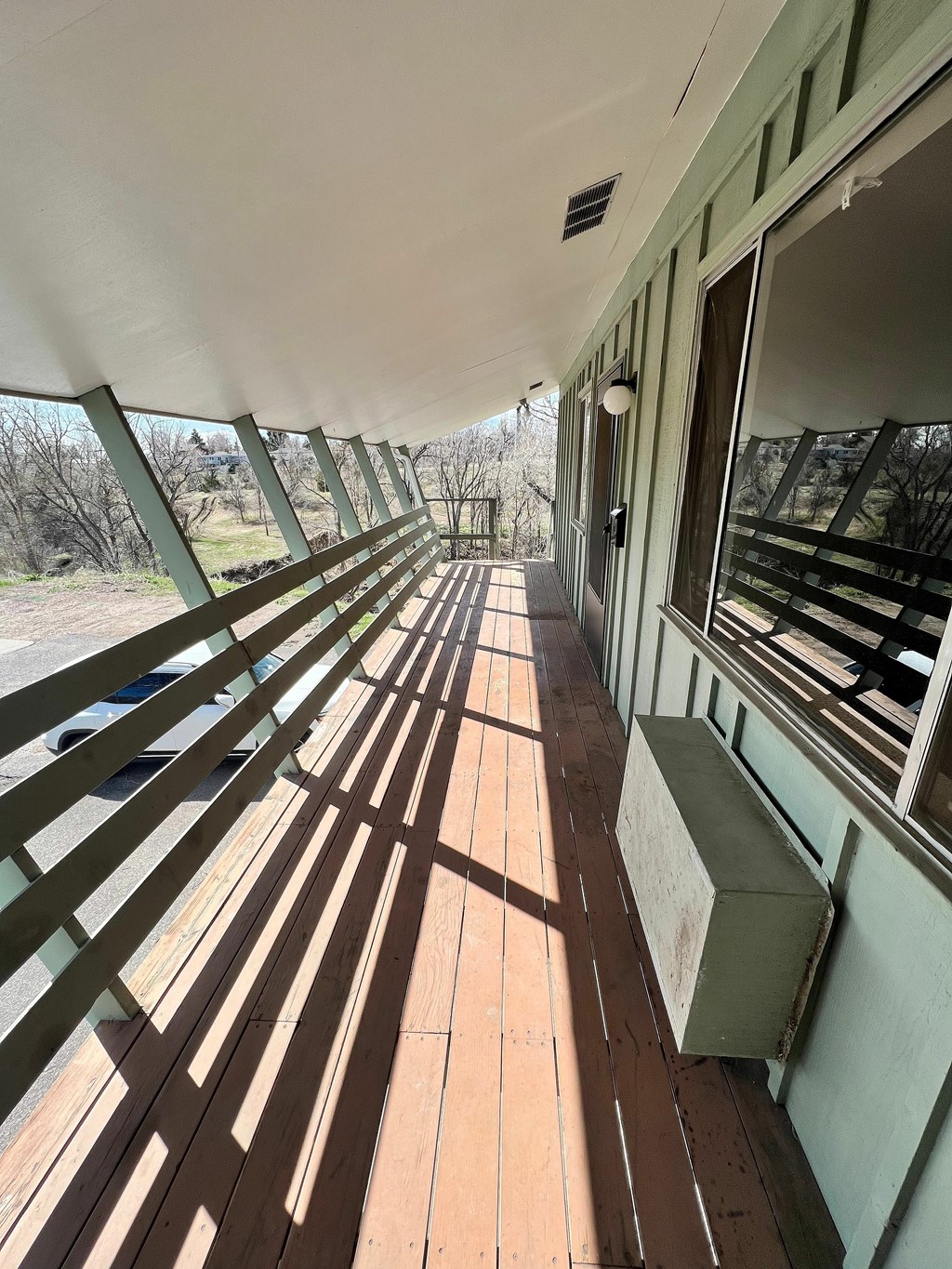 The sun is shining on the wooden deck of a train car.