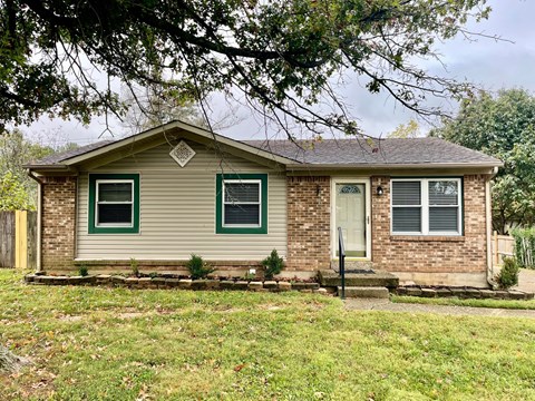 A house with a green front door and a brown front porch.